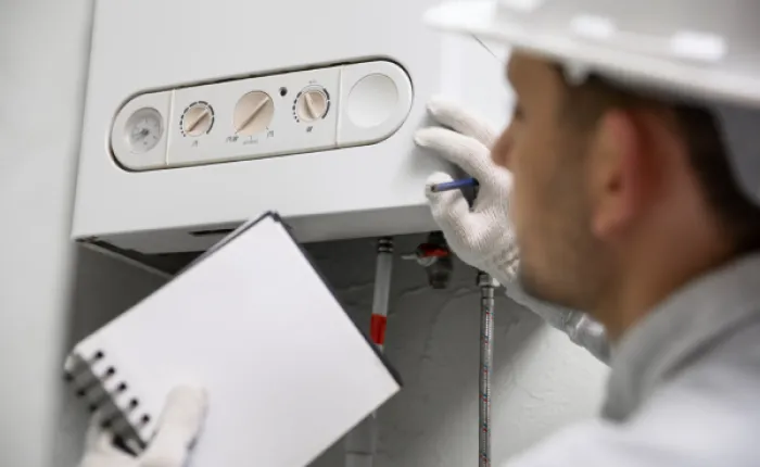 Technik opravuje topení pro úsporu energie v domácnosti