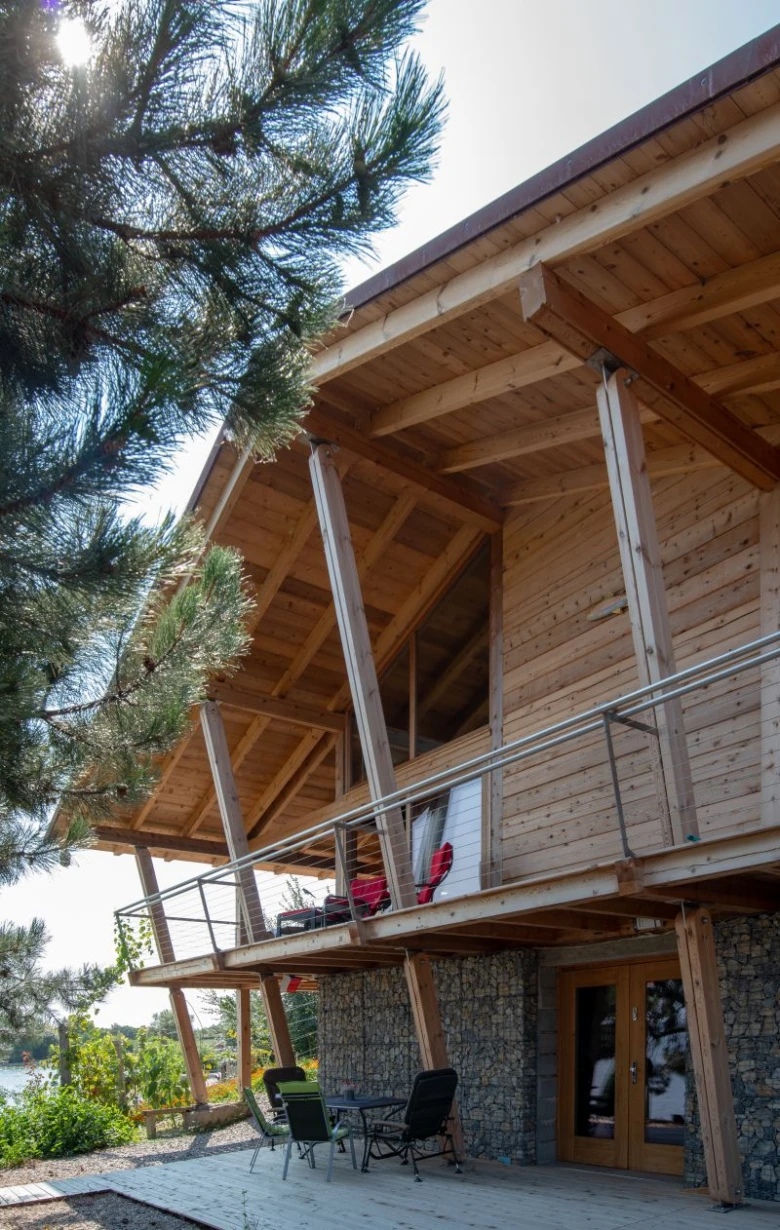 Dřevěný dům s kamenným základem a venkovním posezením