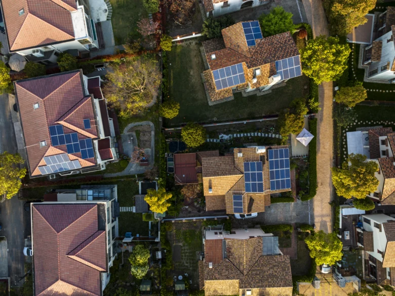 Vzdušný pohled na rodinné domy s fotovoltaickými panely.