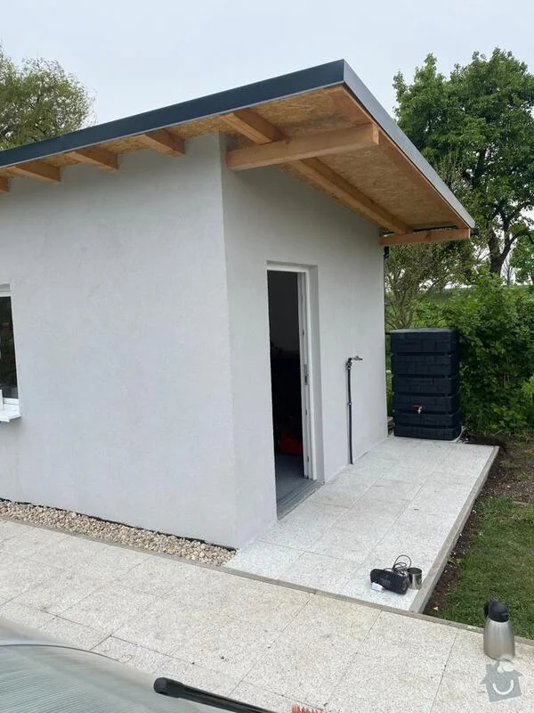 Nově postavený zahradní domek s otevřeným vchodem a dlažbou.