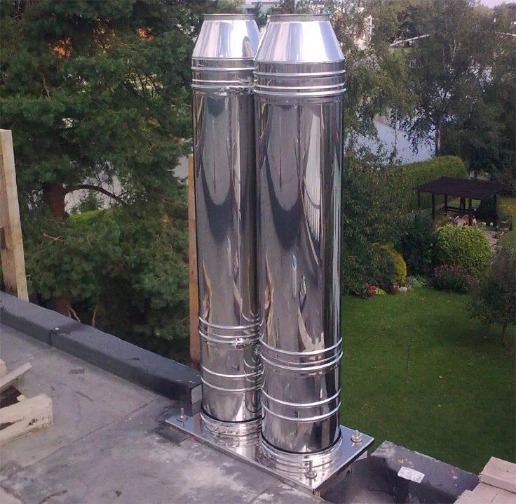 Dva nerezové komínové ventilátory na střeše.