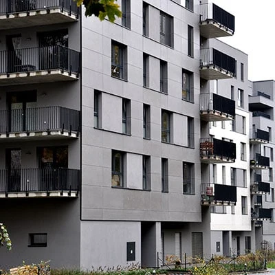 Moderní fasáda z desek na obytném domě s balkony.