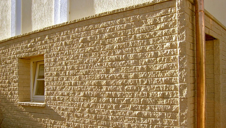 Bílá fasádová obkladová dlažba s texturou cihly na exteriéru domu.