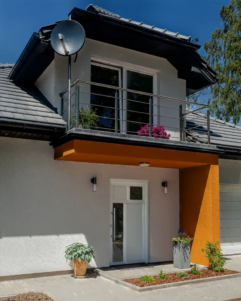 Moderní bílé vstupní dveře do domu s balkónem.