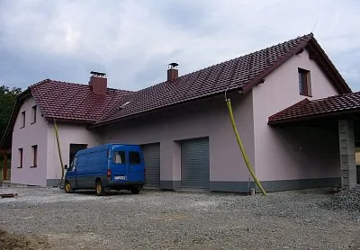 Nová dům s tepelně izolační omítkou a červenými střechami.