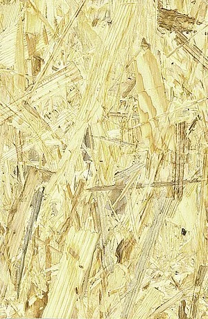 Detailní záběr na povrchovou strukturu desky z orientovaných dřevěných vláken.