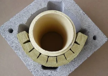 Žlutá nehořlavá izolace kolem keramického kouřovodu v betonové desce.