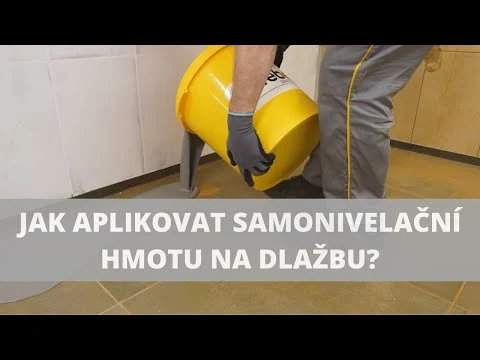 Pracovník nalévá samonivelační hmotu na dlažbu v koupelně.