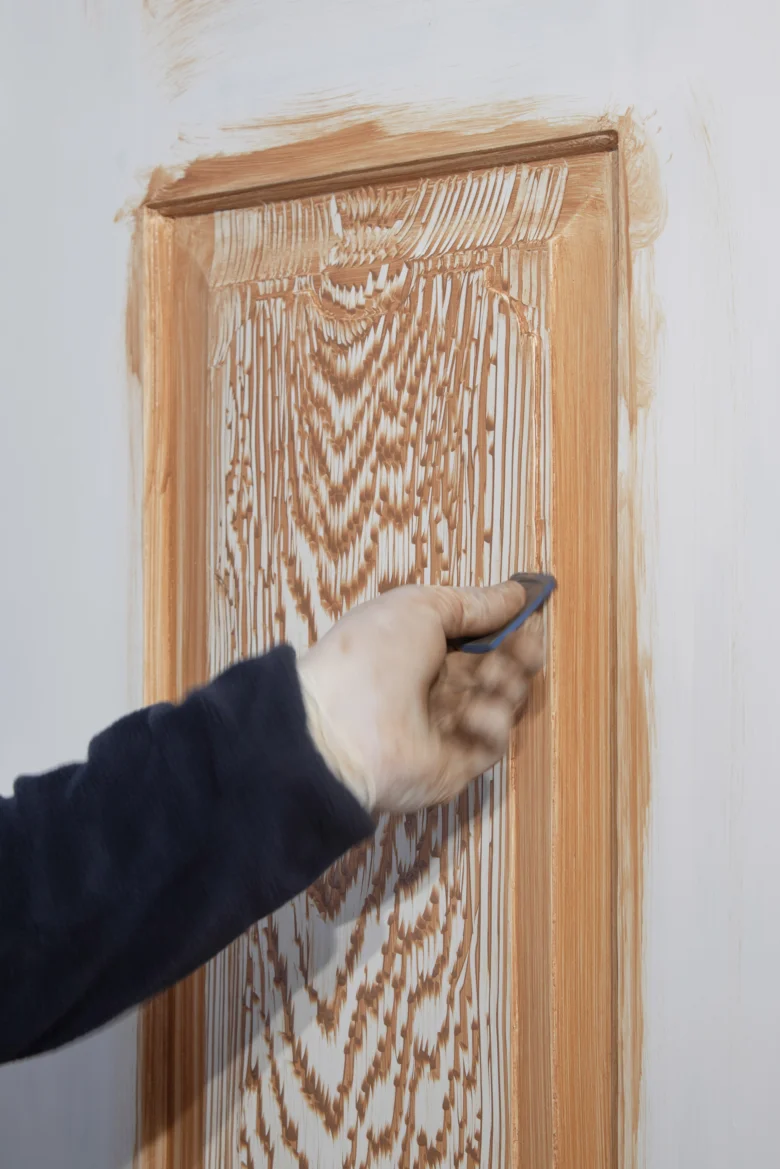 Náplast na dřeve se nanáší štětcem do prasklin dveří.