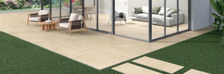 Moderní betonová dlažba na terasu vedle trávníku.