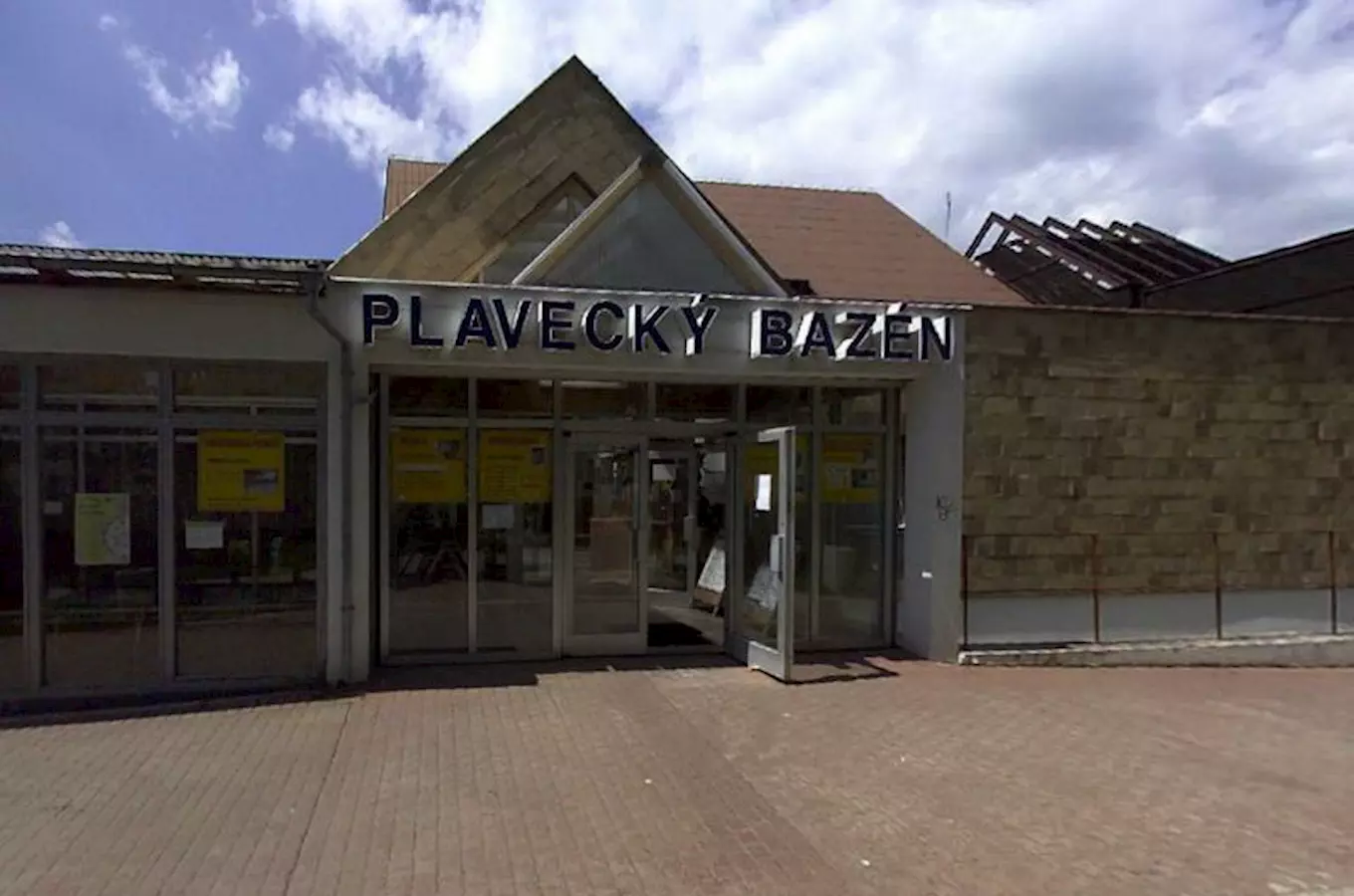 Vstup do plaveckého bazénu v Litoměřicích s nápisem nad dveřmi.