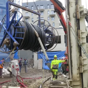 Instalace kabelů pro tepelné čerpadlo země-voda s vrtem na staveništi.
