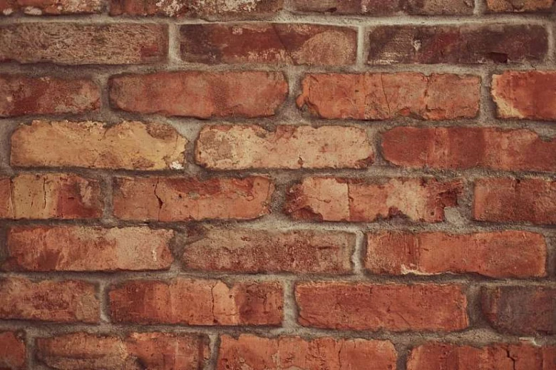 Zdivo z červených cihel s viditelnými švy maltou.