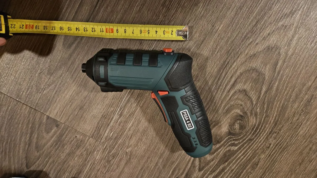 Cordless drill on wood floor with tape measure