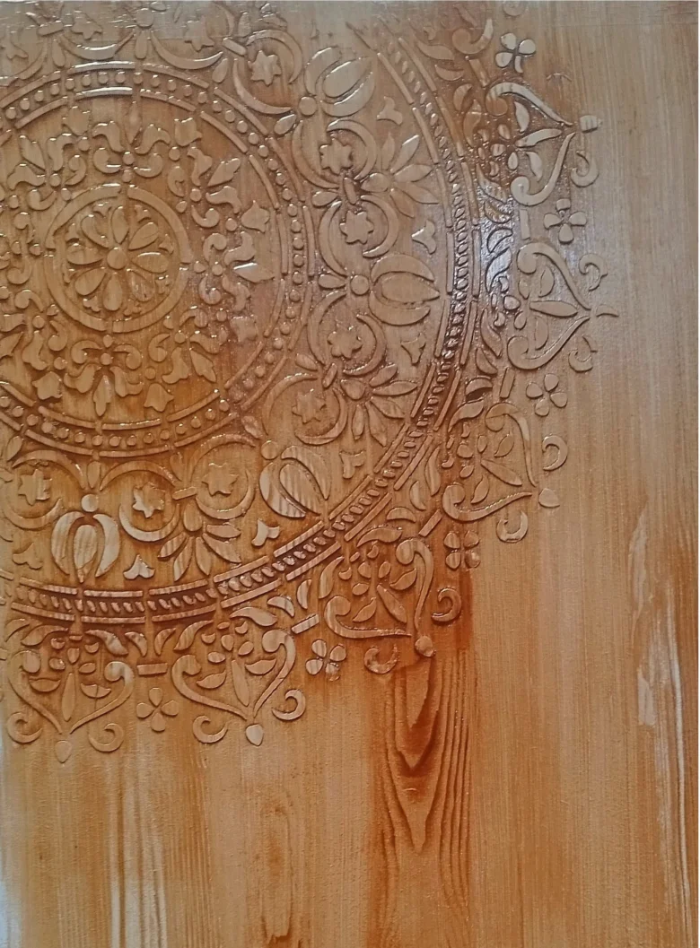 Detail vyřezaného dřeva na dveři po aplikaci dekorativního vzoru.