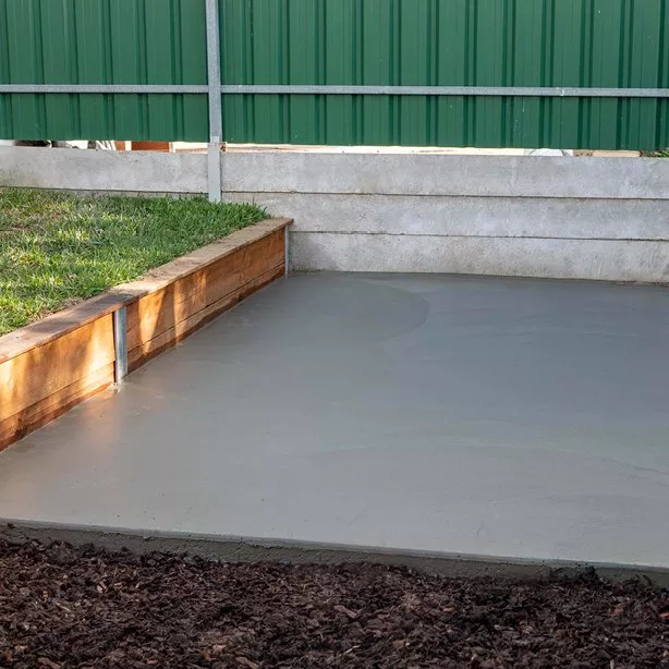 Čerstvě nalitá betonová podlaha vedle dřevěného zdiva.