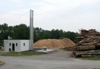 Náklad dřevitých biomasy na skladu v průmyslovém areálu.