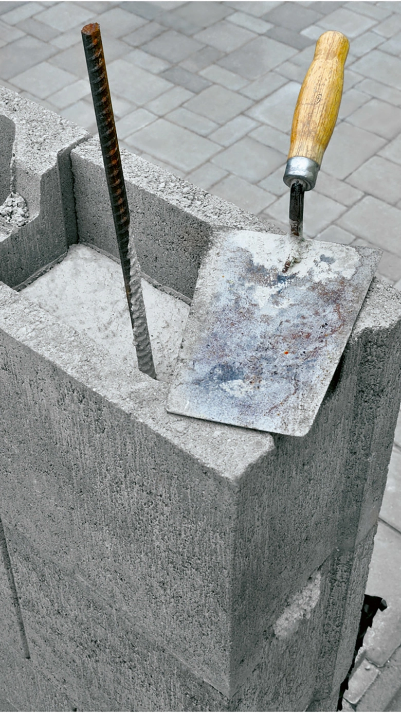Betonový blok s výztuží a nástroji pro ztracené bednění.