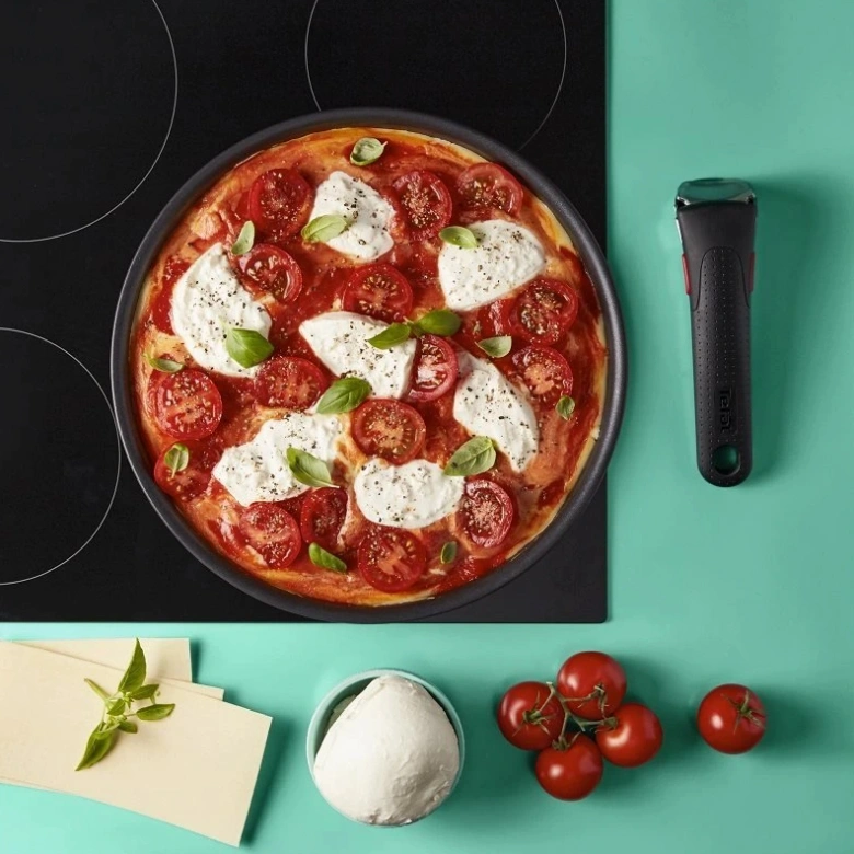 Pizzy na indukční varné desce s čerstvými ingrediencemi.