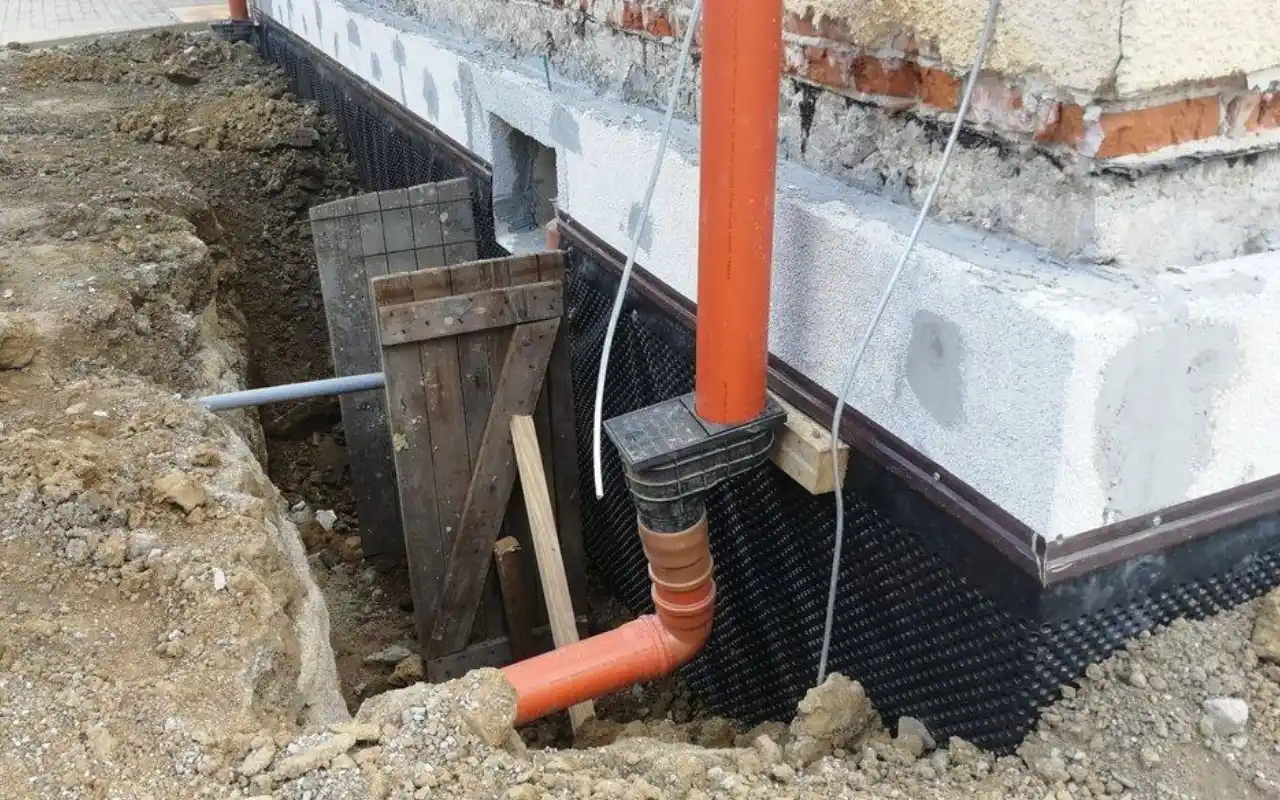 Instalace izolace soklu s odvodňovacím potrubním systémem.