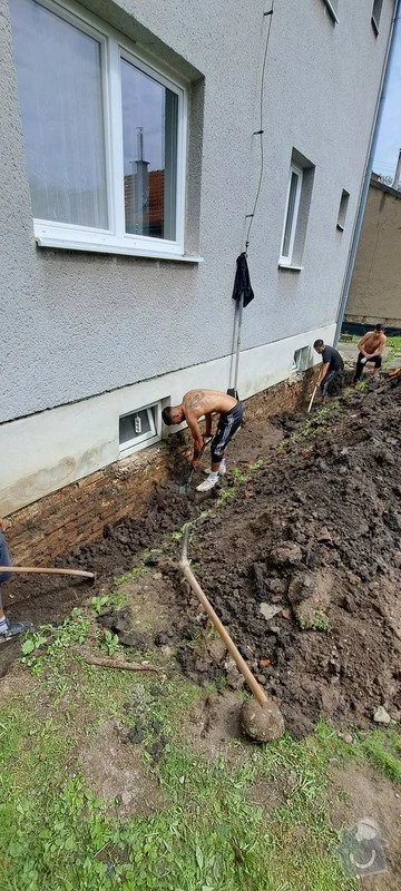 Muži ručně odstraňují zem u základů domu v Brně.