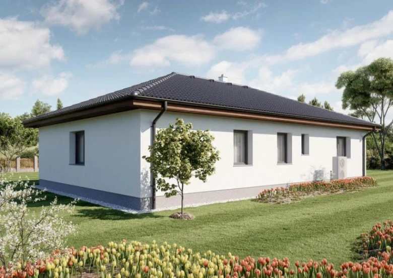 Moderní bílý bungalov s tmavou střechou na zelené trávě.