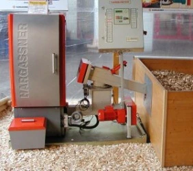 Stroj na zpracování biomasy s dřevitými štěrkami kolem.