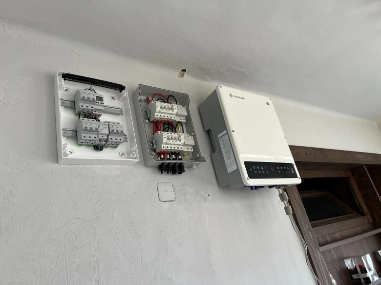 Fotovoltaický měnič s elektrickým rozvaděčem na zdi.