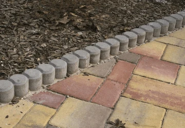 Betonové obrubníky jsou položeny vedle dlažby.