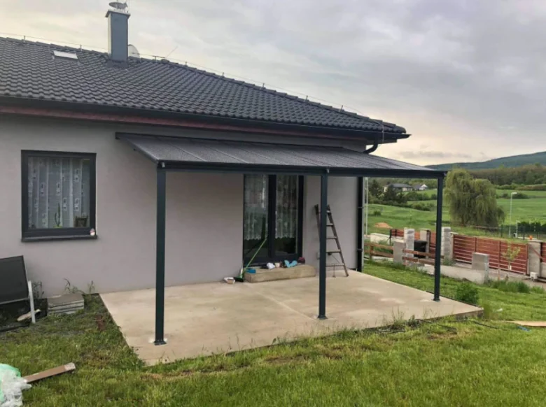 Nová kovová pergola s montovanými sloupky na terase domu.