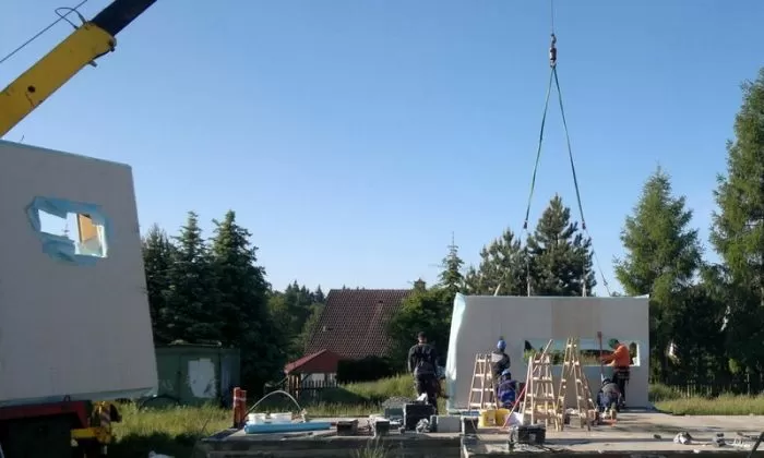 Stavební práce na dřevěné chatě s výhybami stěn.