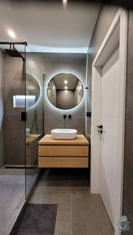 Moderní koupelna po renovaci s dřevěnou vanou a skleněným sprchovým boxem.