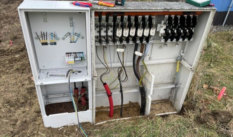 Otevřený elektroměrový rozvaděč s viditelným zapojením jističů a vodičů.
