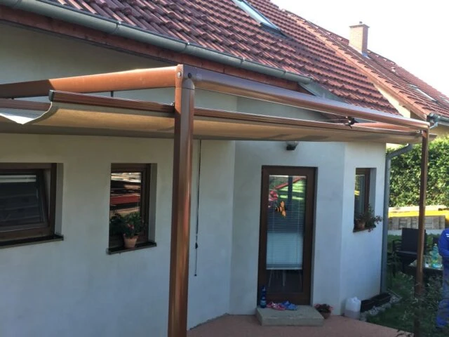 Rozkládací pergola s plachtou na terase domu.