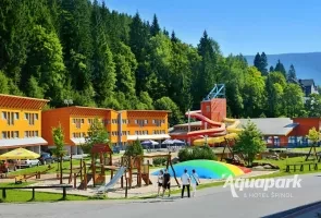 Vnější pohled na aquapark ve Vrchlabí s bazénymi a skluzavkou.