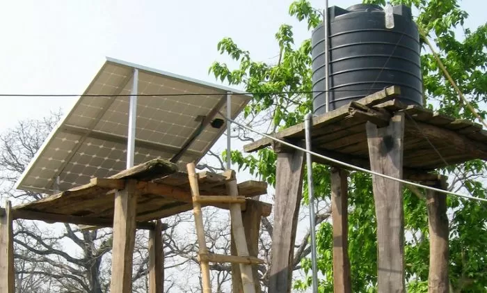 Solární panely ohřívají vodu pro bazén na dřevěném podstavci.