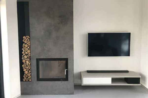 Moderní interiér s betonovou stěnou u krbu a televizorem.