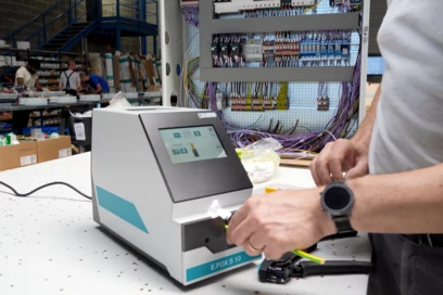Technik používá přístroj pro kontrolu elektrického rozvaděče v továrně.