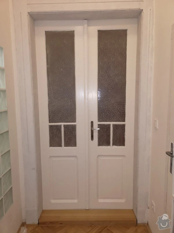 Bílé dvoudveřové dveře s matným sklem po renovaci v domě.